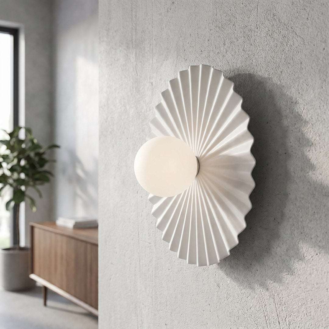 Gros plan de l’applique allumée sur un mur texturé, intérieur lumineux.