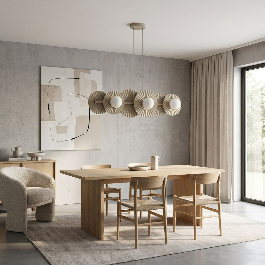Ambiance salle à manger en bois clair, suspension beige et fauteuil bouclé à gauche