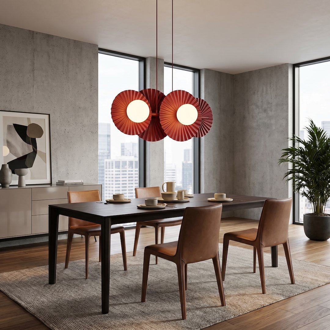 Mise en ambiance dans une salle à manger béton, suspension rouge au-dessus d'une table dressée.