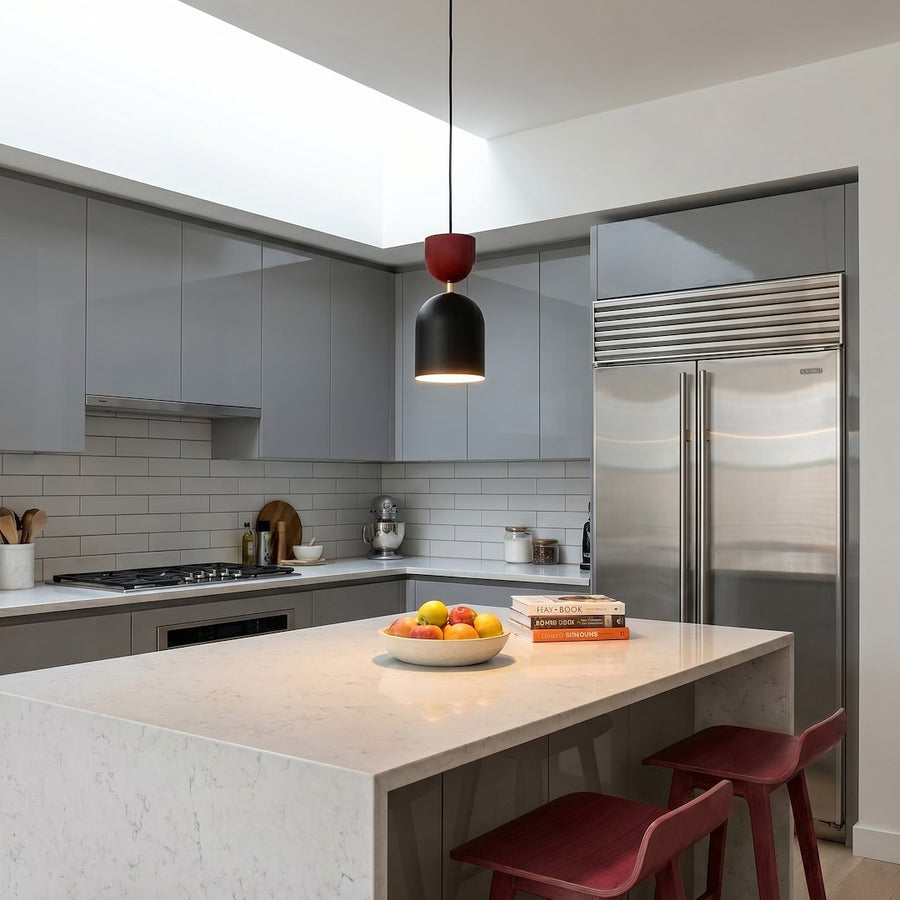 Cuisine moderne avec îlot central, suspension bordeaux et noire au-dessus du plan de travail.