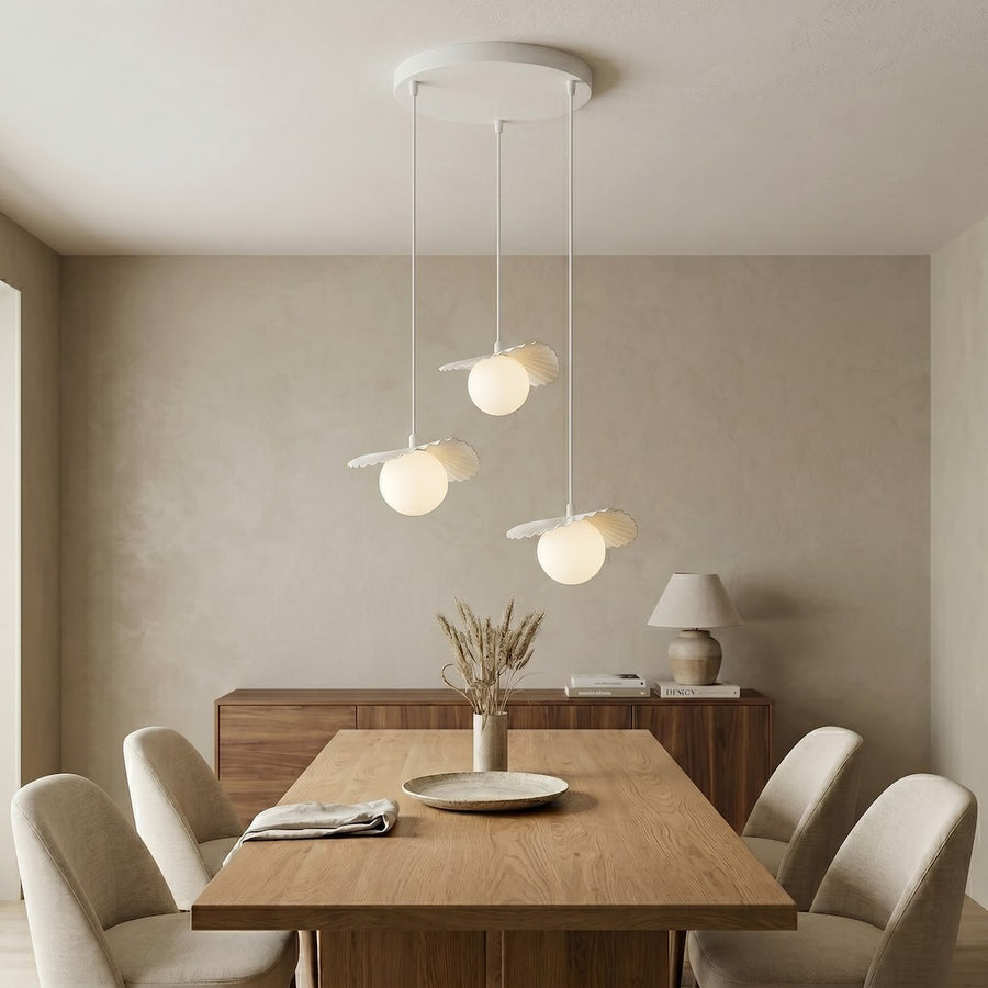 Intérieur contemporain avec suspension allumée, table en bois et chaises beiges.
