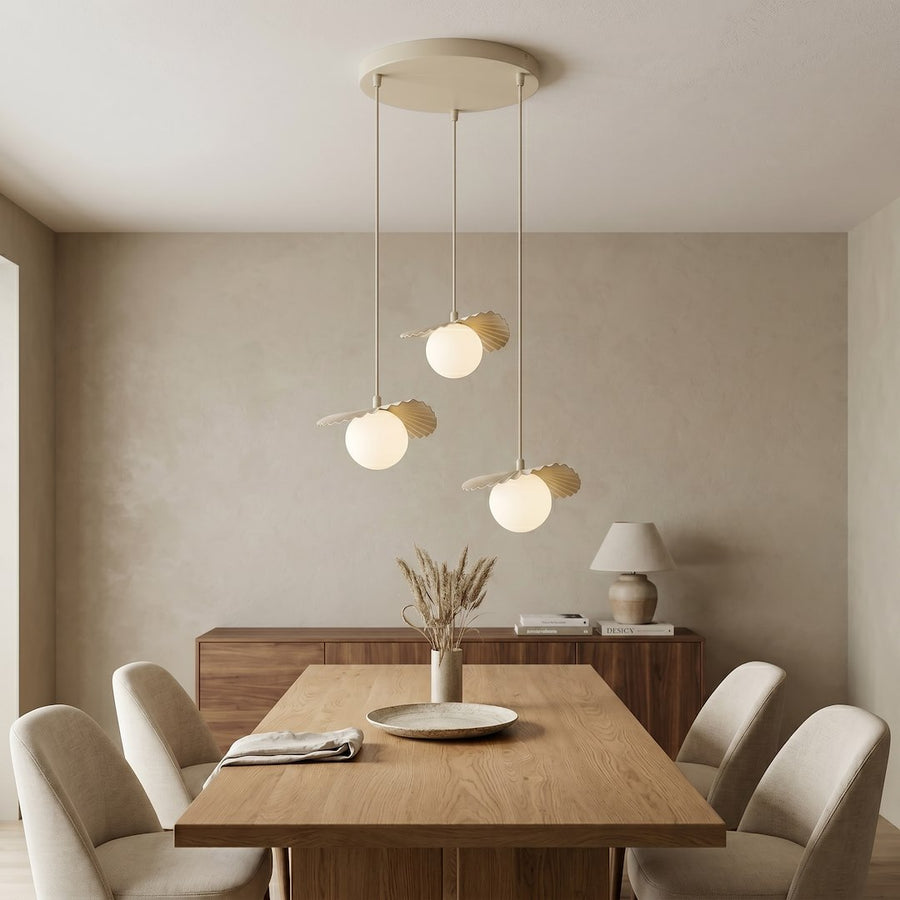 Salle à manger beige avec buffet en bois, suspension éclairée au-dessus de la table.