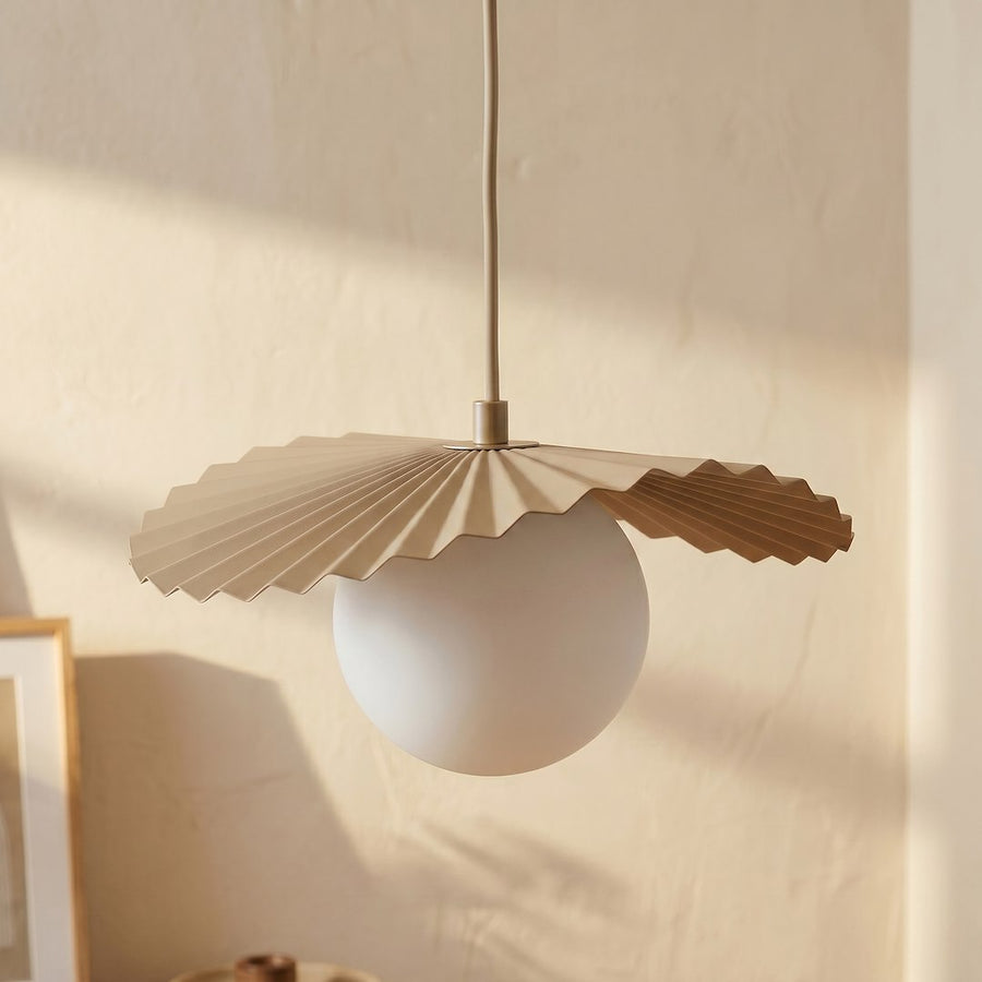 Gros plan sur un globe de verre blanc et sa collerette plissée beige.