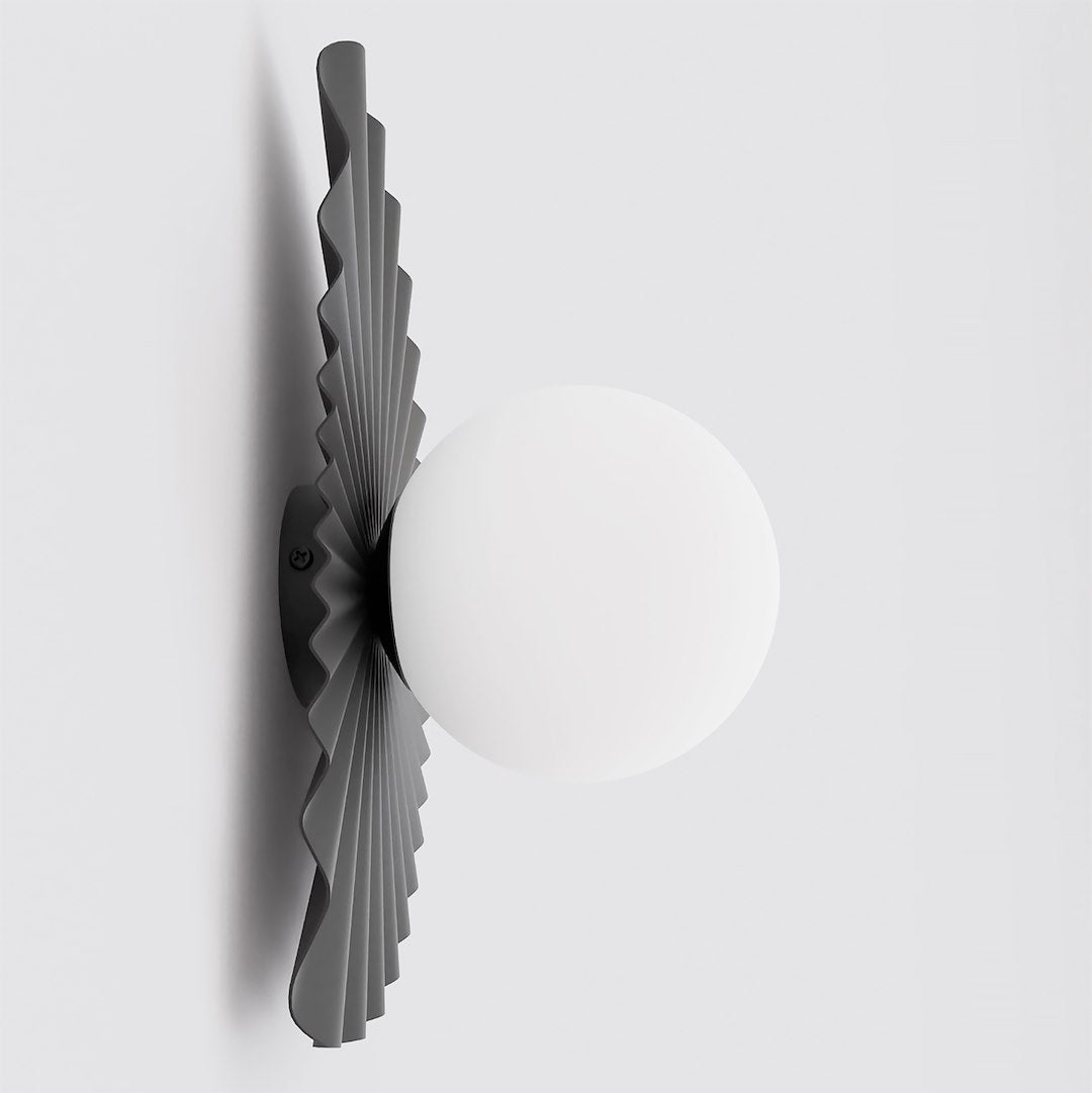 Vue de profil : applique murale noire plissée et globe de verre blanc en saillie.