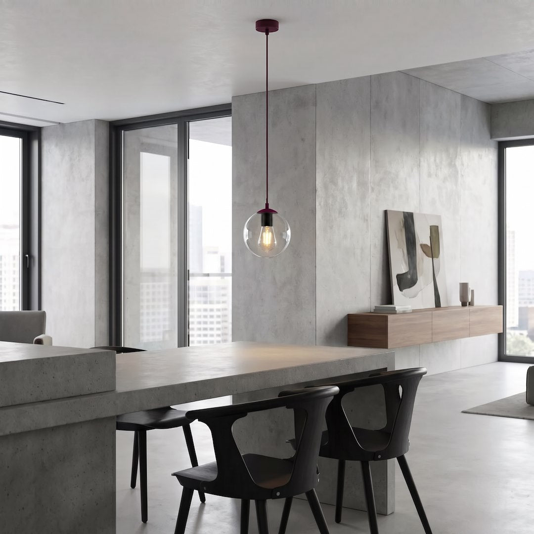 Suspension globe en verre transparent suspendue au-dessus d'une table en béton, intérieur moderne.