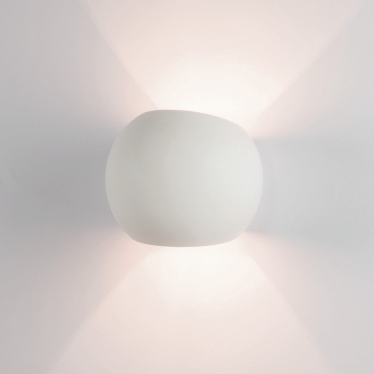 Vue rapprochée du diffuseur arrondi blanc, lumière rasante sur la paroi