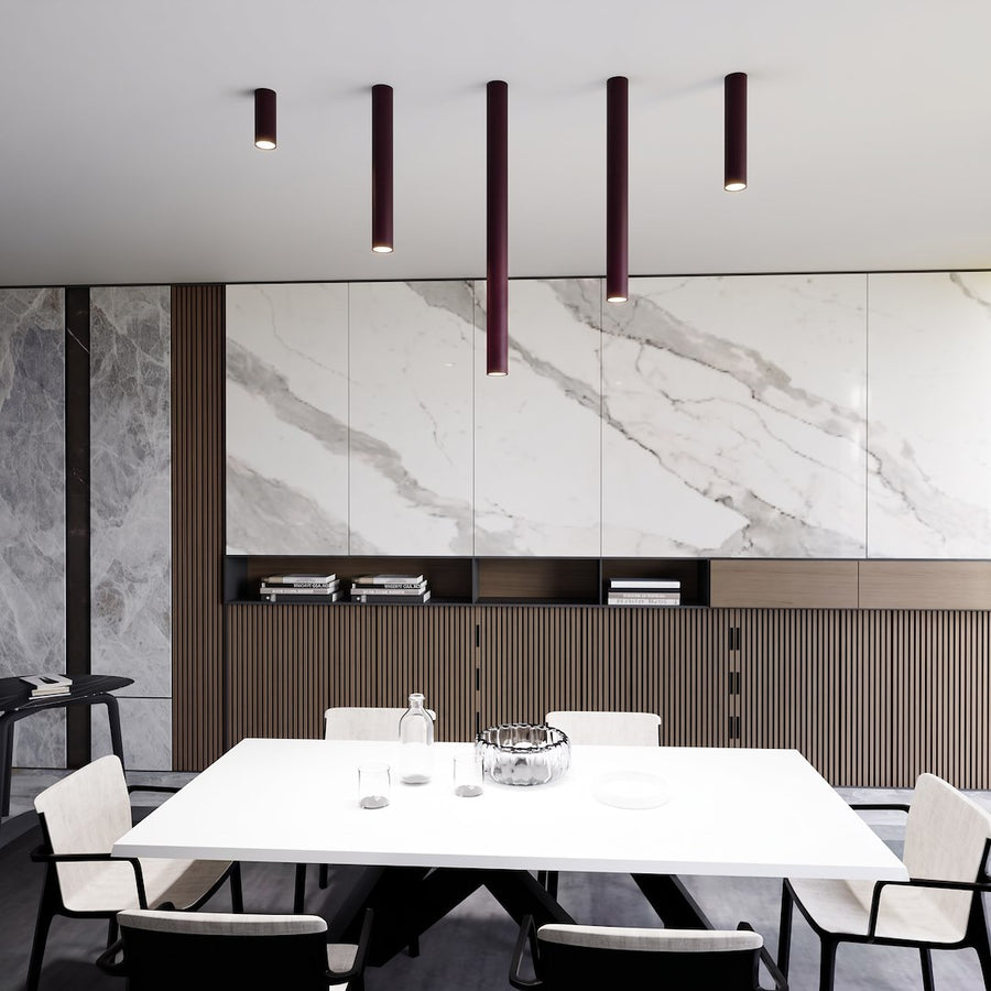 Cinq tubes de longueurs différentes éclairant une table dans un intérieur moderne