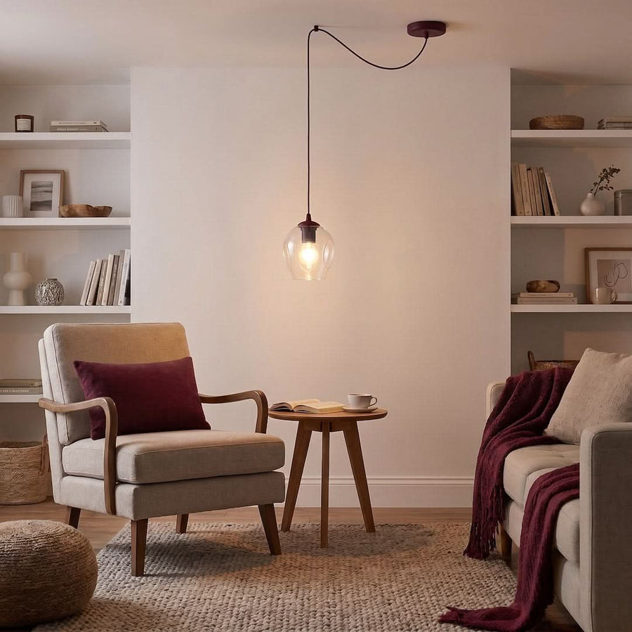 Suspension allumée dans un salon beige avec fauteuil, table d'appoint et étagères