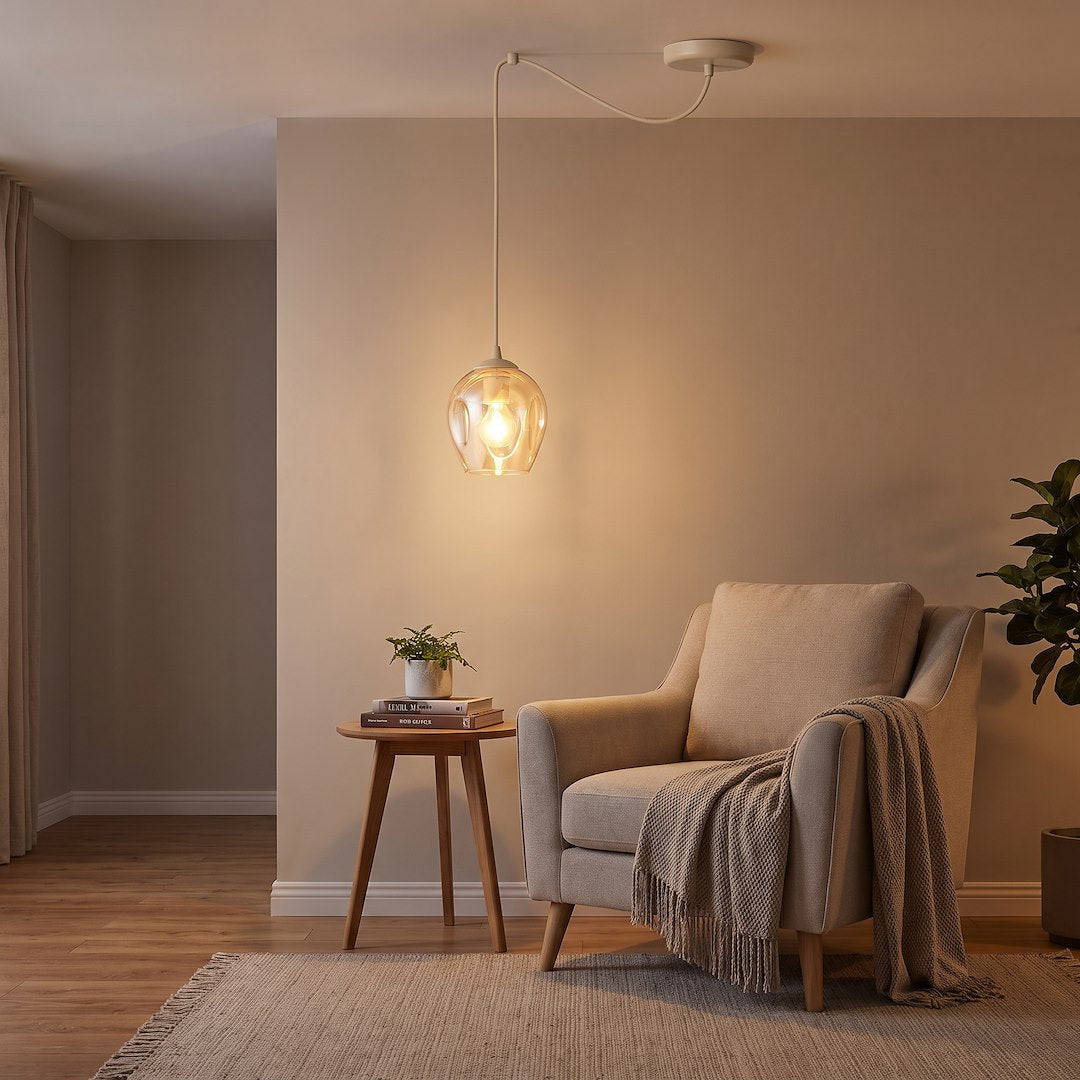 Mise en ambiance salon avec suspension allumée près d'un fauteuil beige