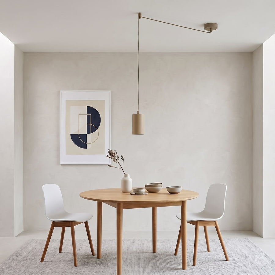 Vue en situation au-dessus d'une table à manger, suspension beige fine près d'un mur clair.