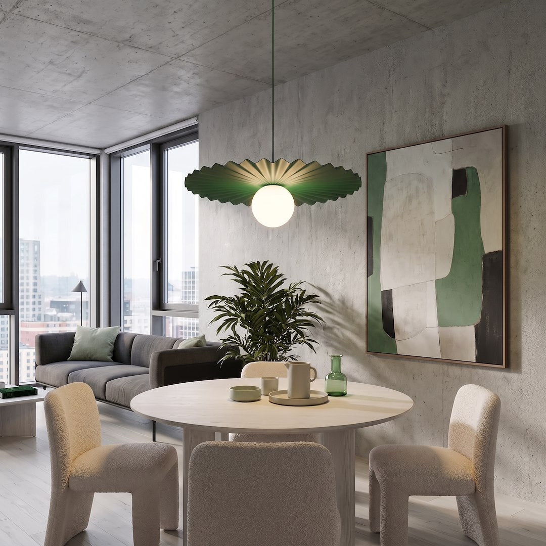 Intérieur béton, suspension plissée verte allumée éclairant une table et un fauteuil