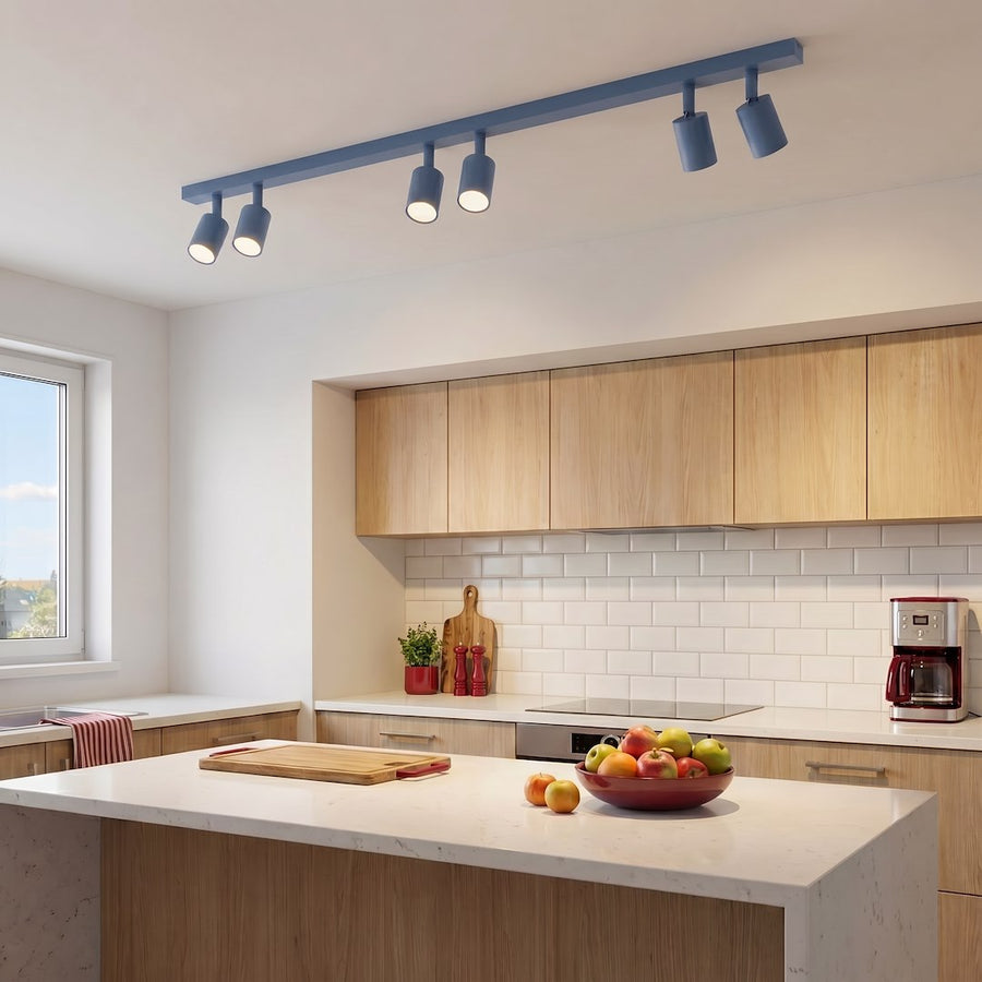 Cuisine en bois clair, luminaire bleu allumé au-dessus du plan de travail