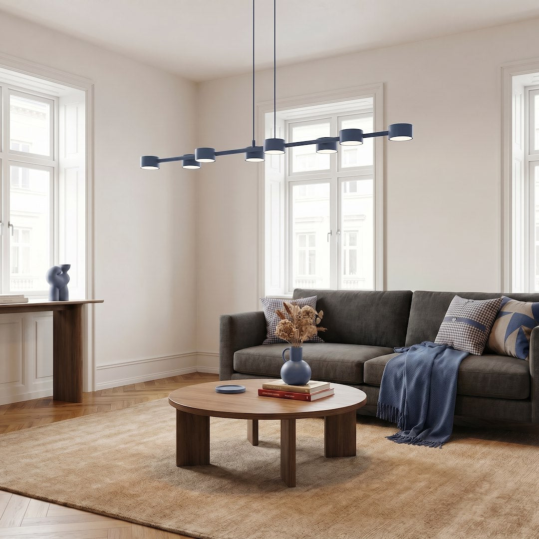 Mise en ambiance d'un salon contemporain, canapé gris et suspension bleue au-dessus de la table