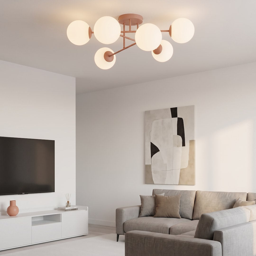 Mise en ambiance dans un salon, plafonnier allumé au-dessus d'un canapé gris et d'un téléviseur.