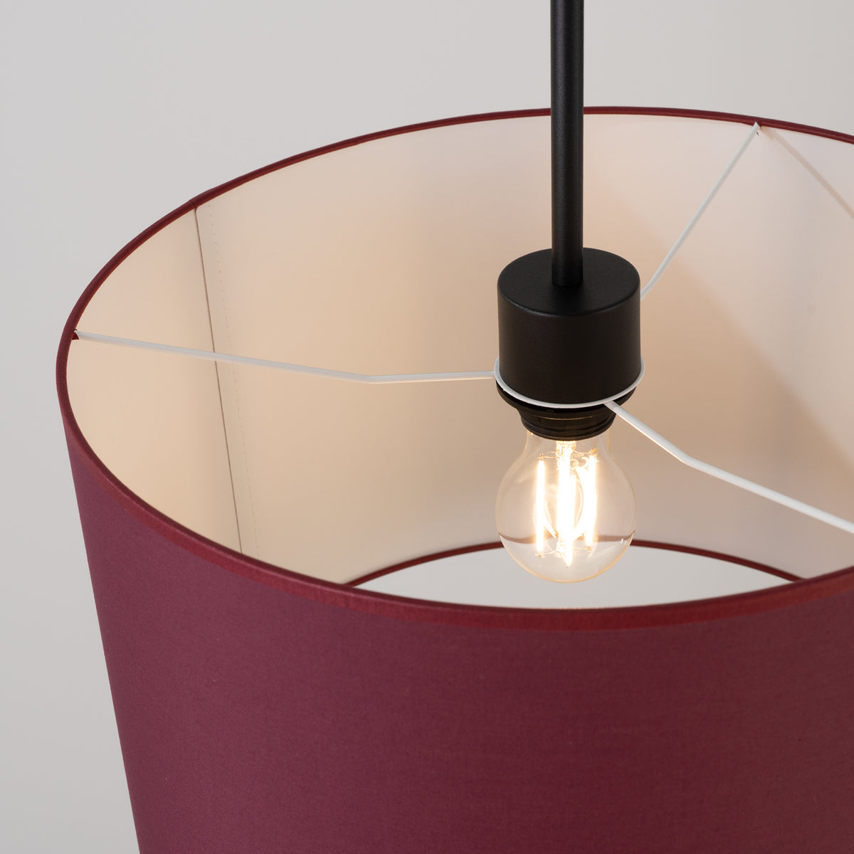 Détail de l'intérieur, douille noire, ampoule LED allumée et armature métallique