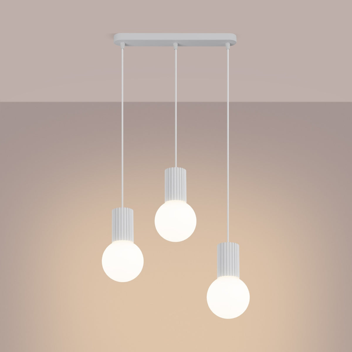 Ambiance sur fond beige, suspension blanche allumée avec halos doux autour des trois globes.