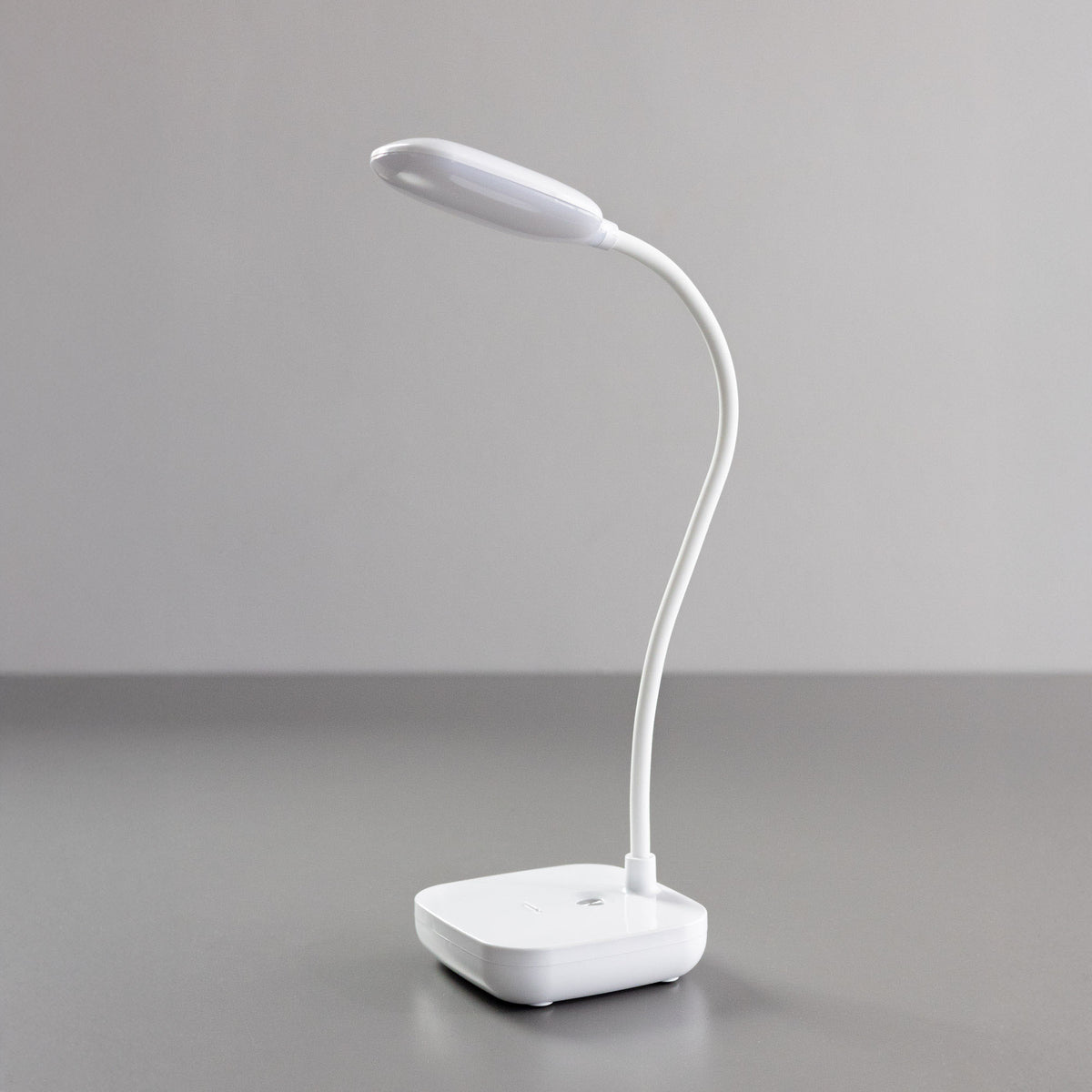 Lampe de bureau blanche éteinte, vue de profil sur fond gris