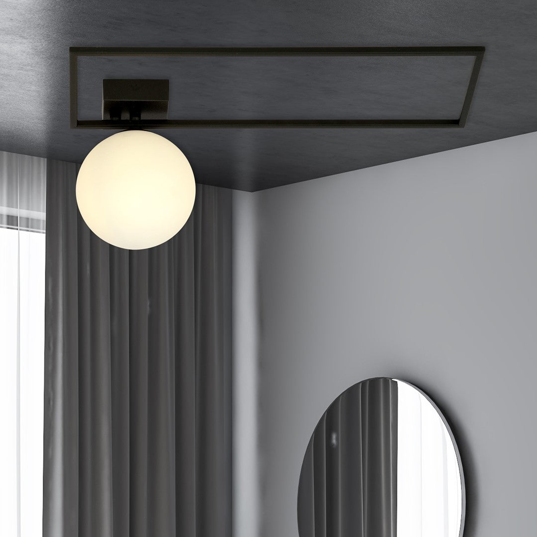 Mise en ambiance dans une pièce sombre, plafonnier allumé au-dessus d'un miroir