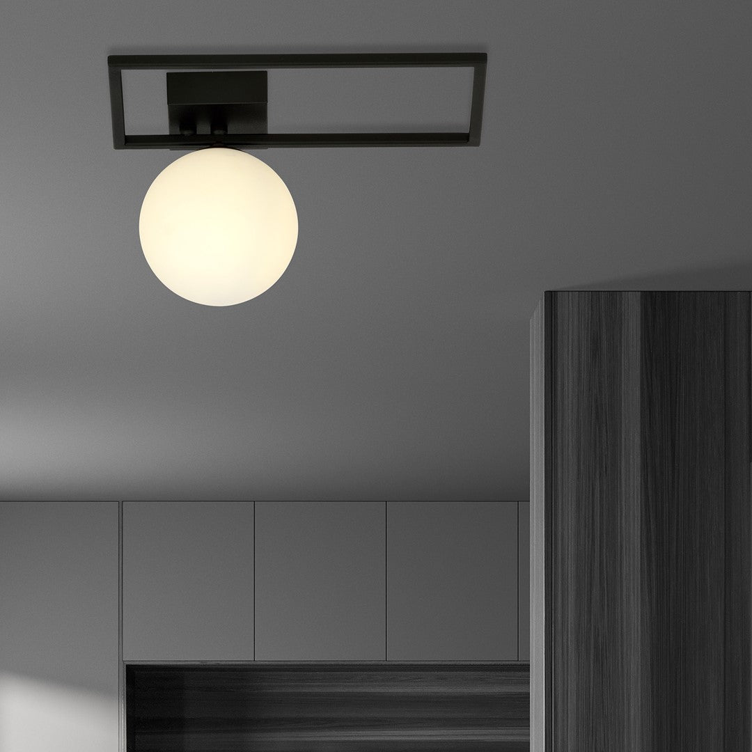 Plafonnier allumé installé au plafond d'une cuisine moderne avec meubles gris et bois.