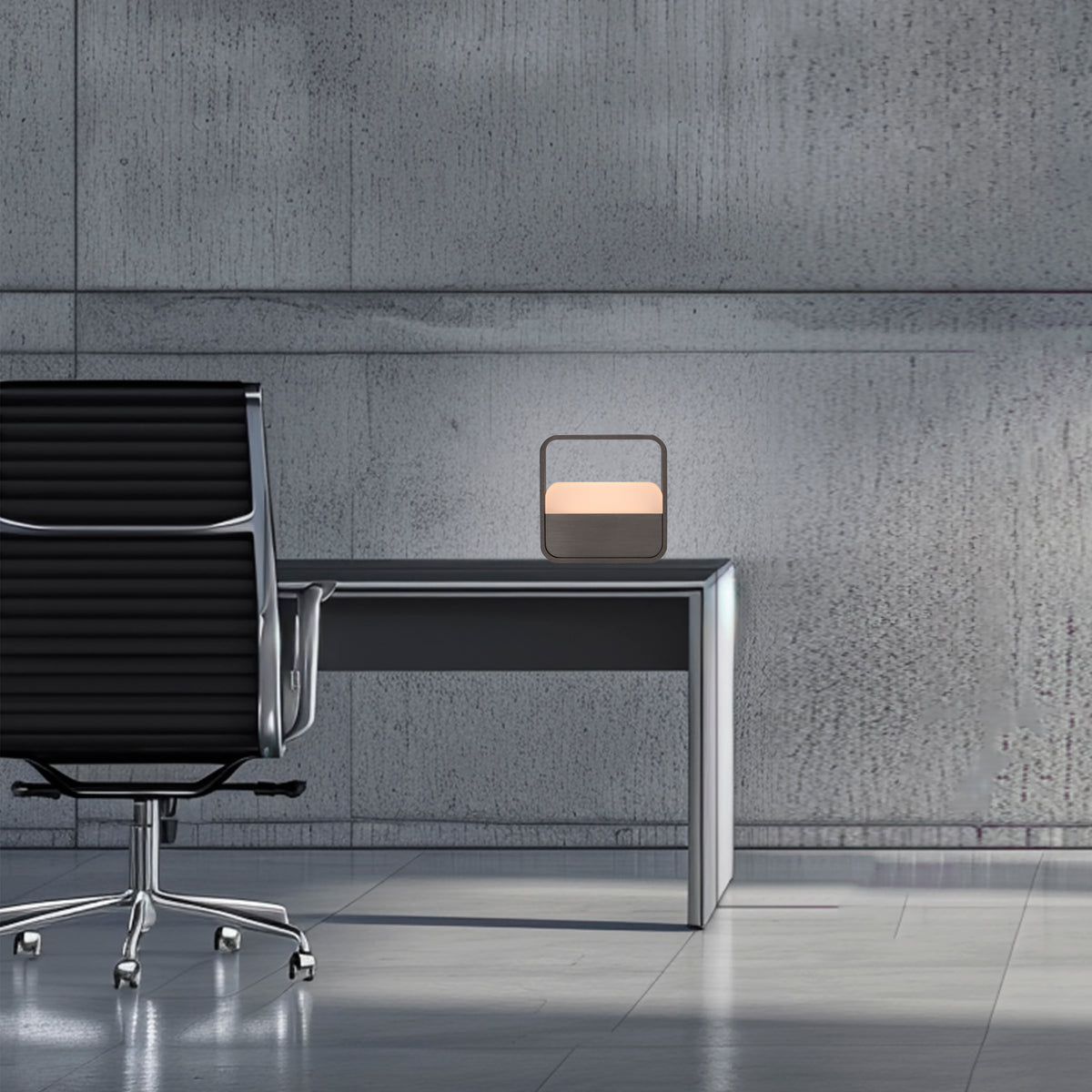 Mise en ambiance sur un bureau moderne, mur béton et chaise de bureau noire.
