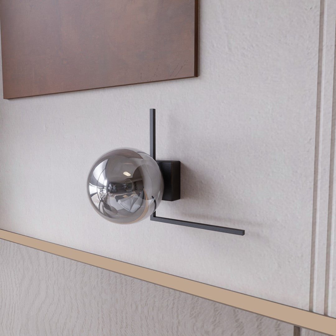 Détail de la sphère fumée reflétant la pièce, posée sur un mur texturé