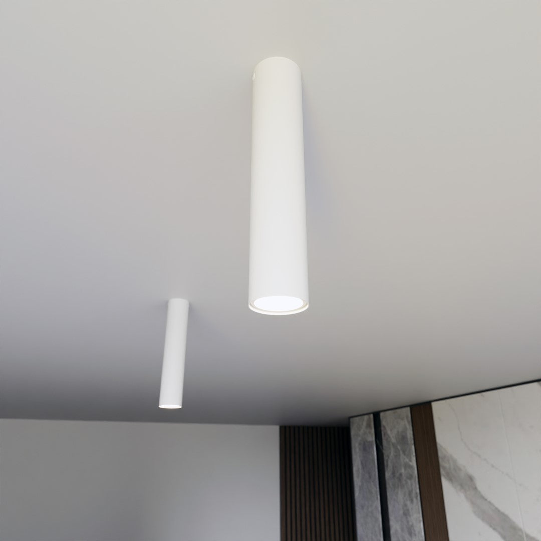 Contre-plongée rapprochée de deux cylindres blancs allumés, fixés au plafond