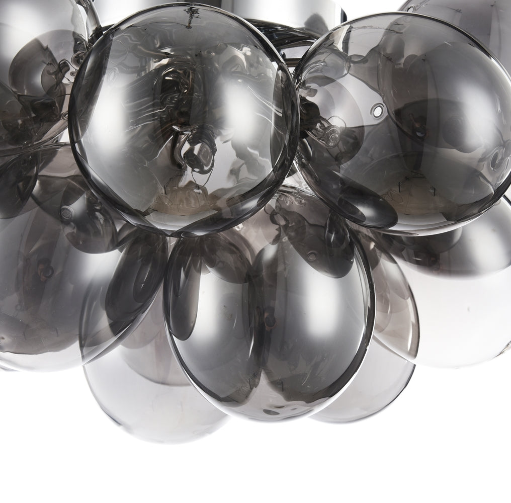 Gros plan sur deux sphères de verre fumé et leurs reflets lumineux.