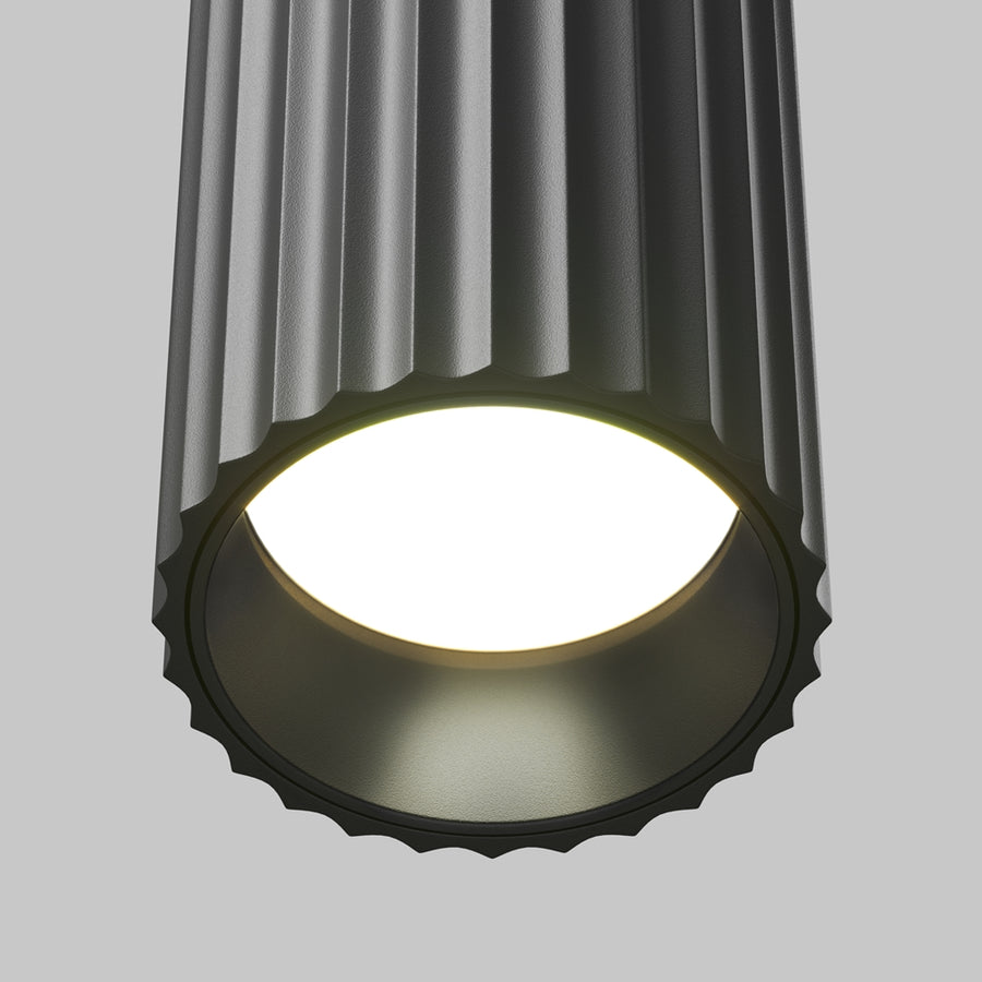 Détail du bas du luminaire, cannelures noires et diffuseur blanc allumé