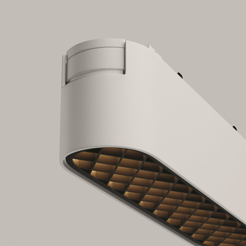 Détail rapproché de la grille nid d'abeille dorée et du corps blanc.