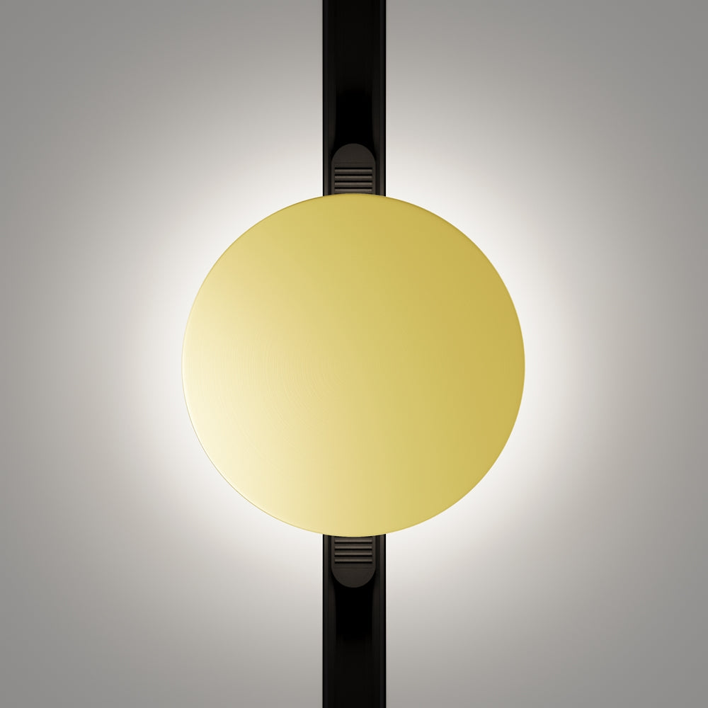 Vue de face du diffuseur circulaire éclairé, halo lumineux et support noir vertical.
