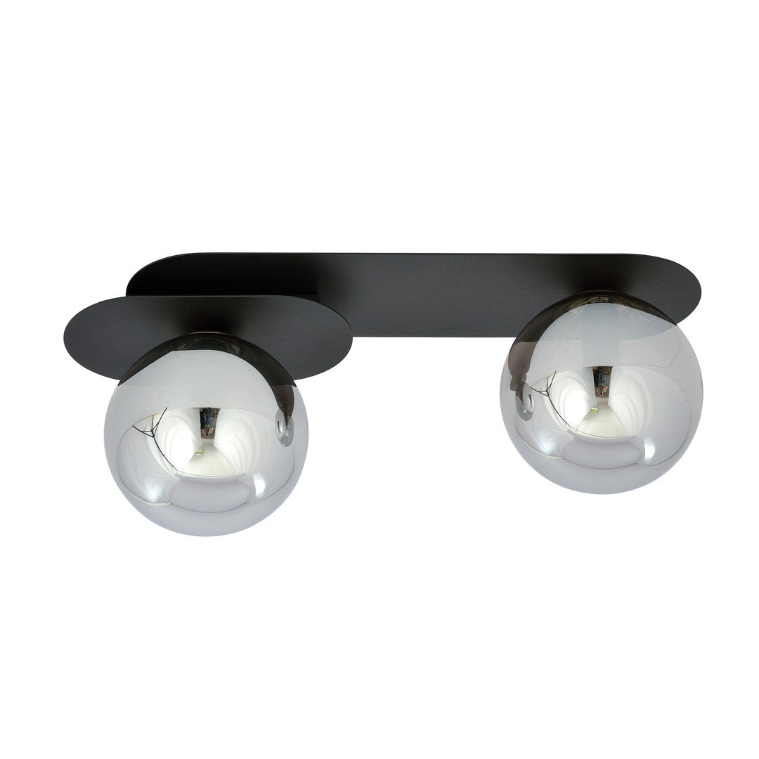 Vue rapprochée des deux boules de verre graphite reflétant la lumière, fond neutre