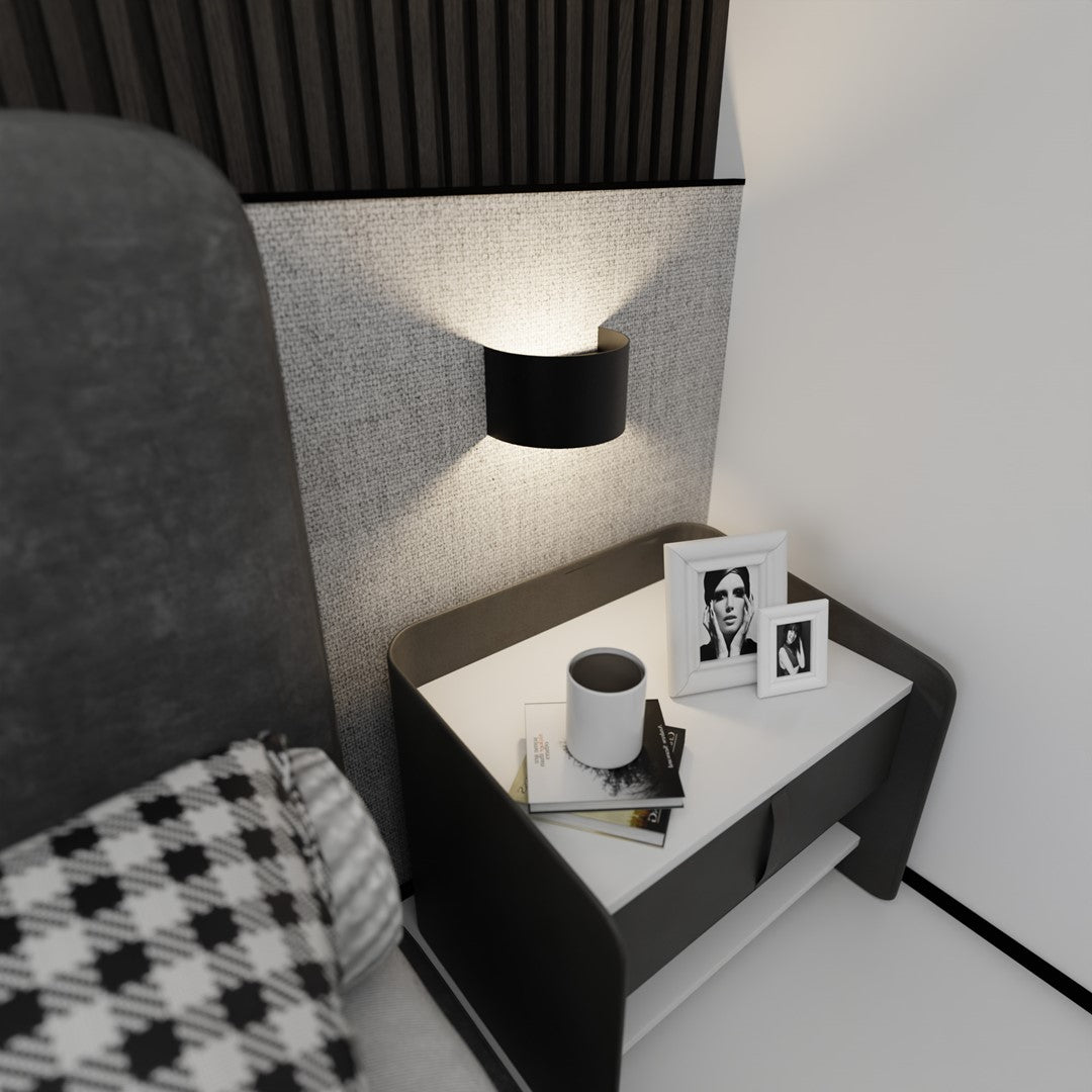 Mise en ambiance chambre, applique noire au-dessus de la table de chevet et du cadre photo