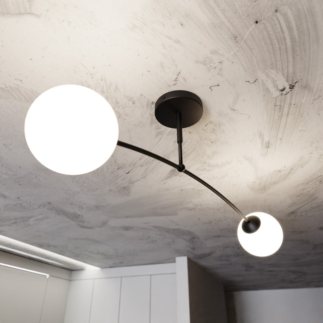 Gros plan sous plafond béton, les deux globes blancs allumés et bras courbé