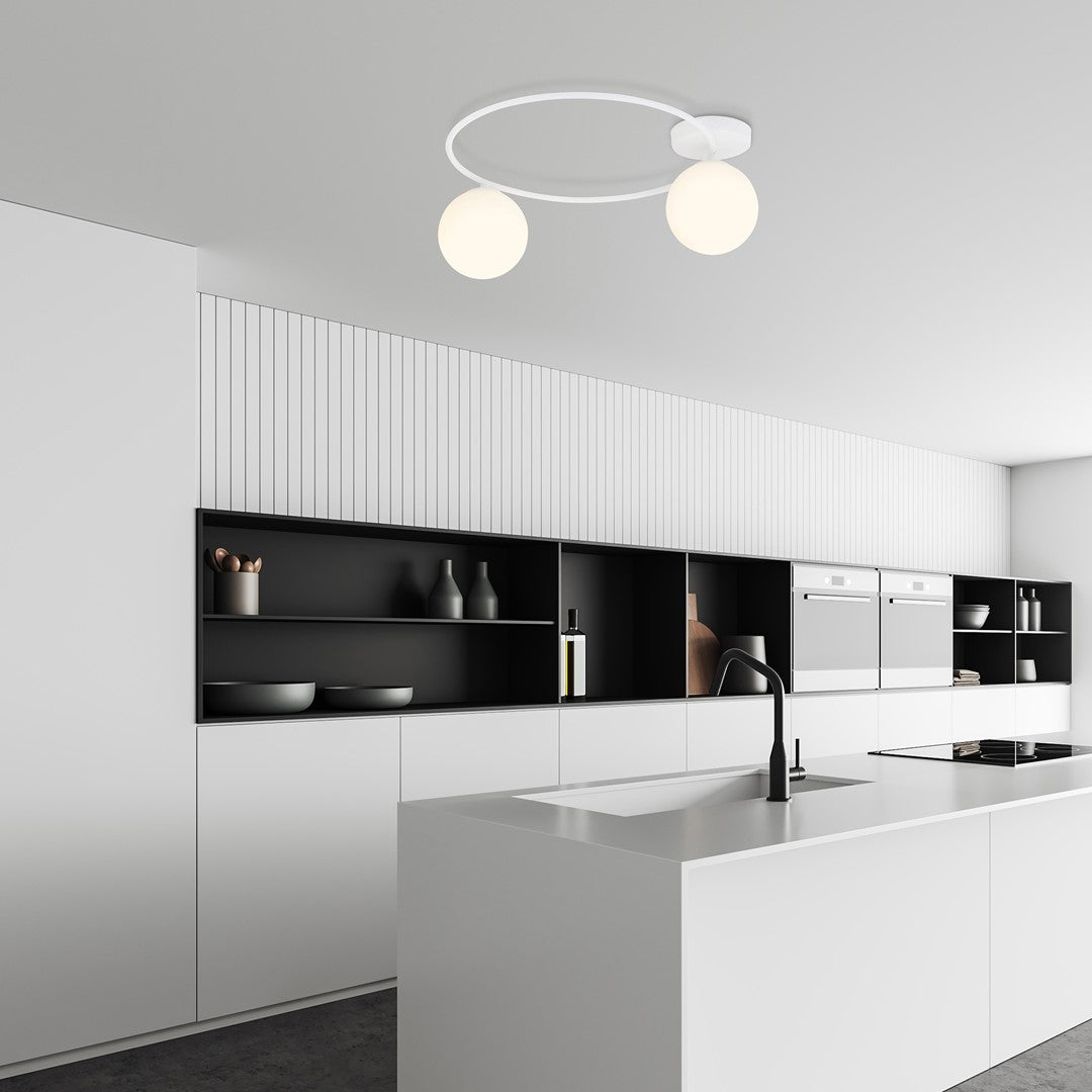 Plafonnier allumé au-dessus d'un îlot de cuisine blanche minimaliste