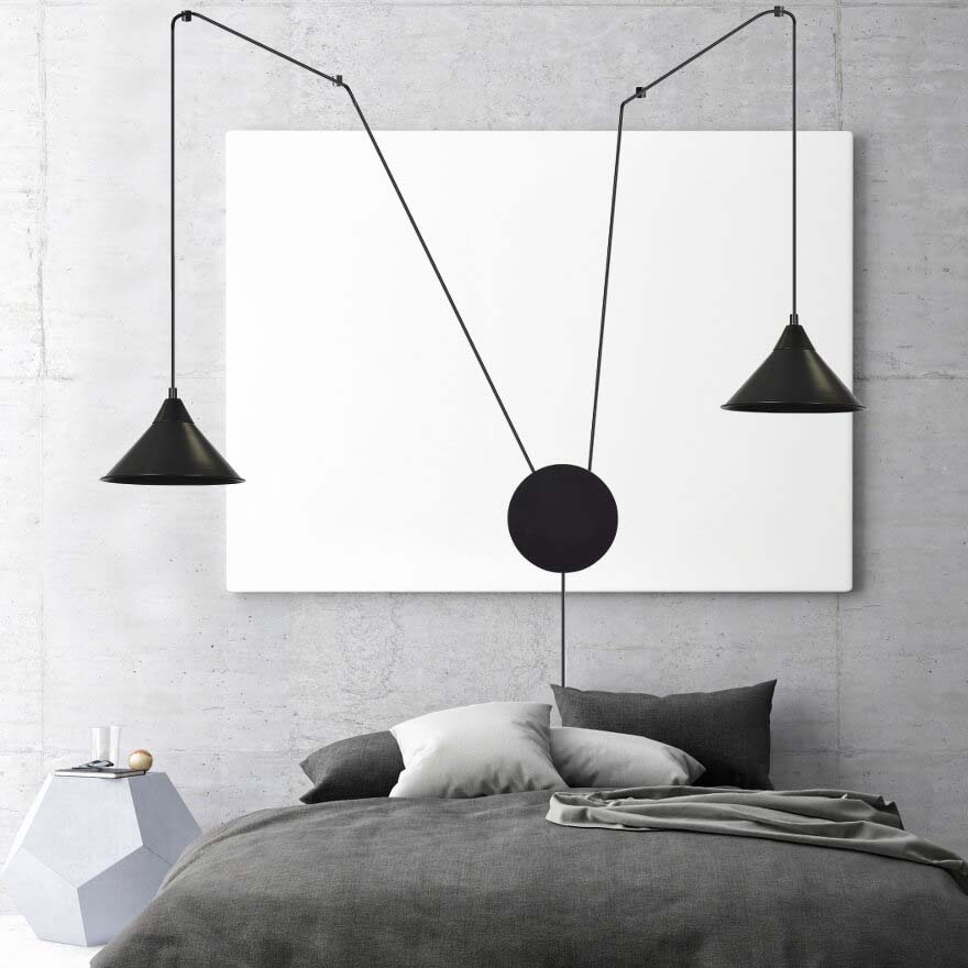 Mise en ambiance chambre, luminaire noir suspendu au-dessus du lit devant un panneau blanc