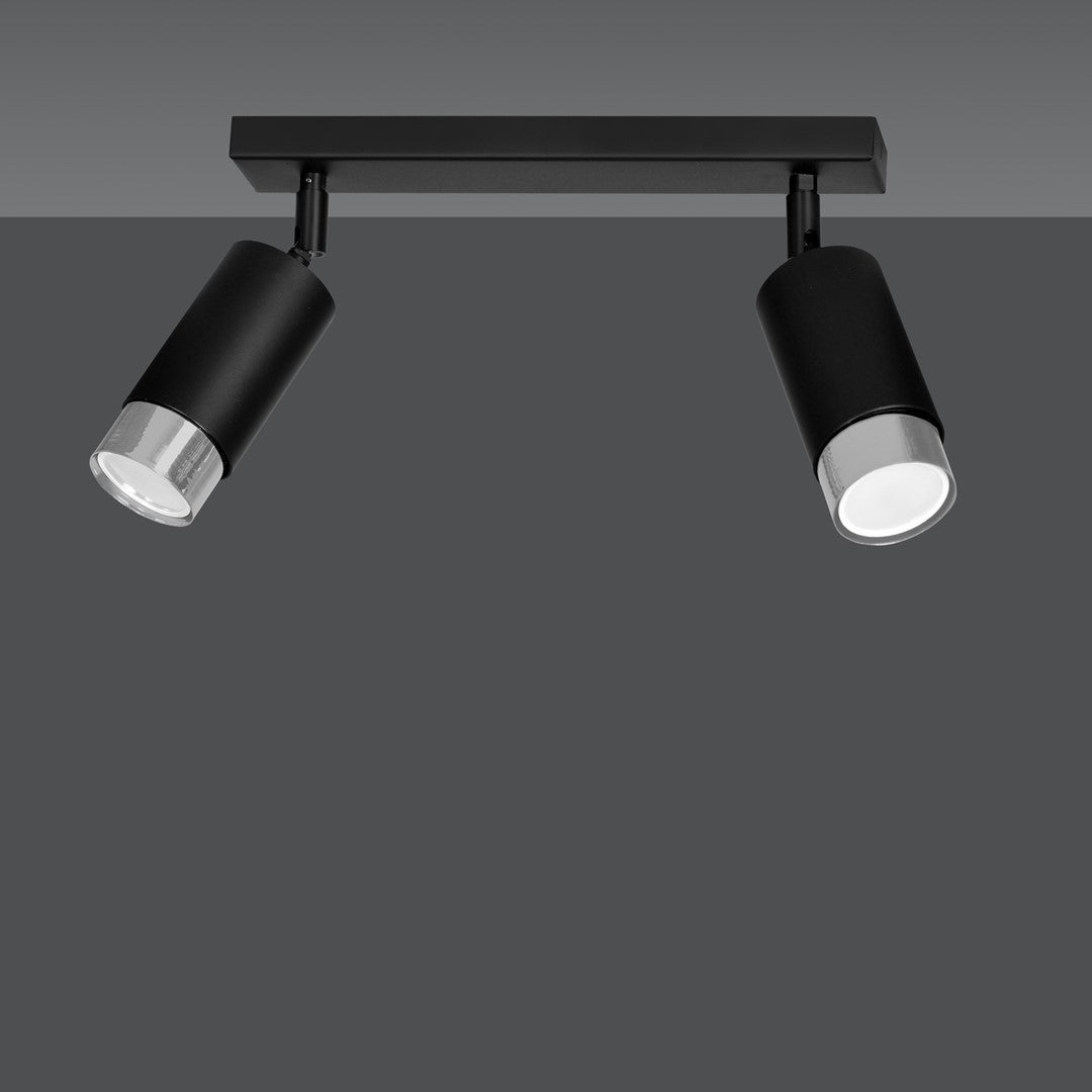 Vue rapprochée du luminaire double sur fond gris, corps noir mat et cerclage chromé.