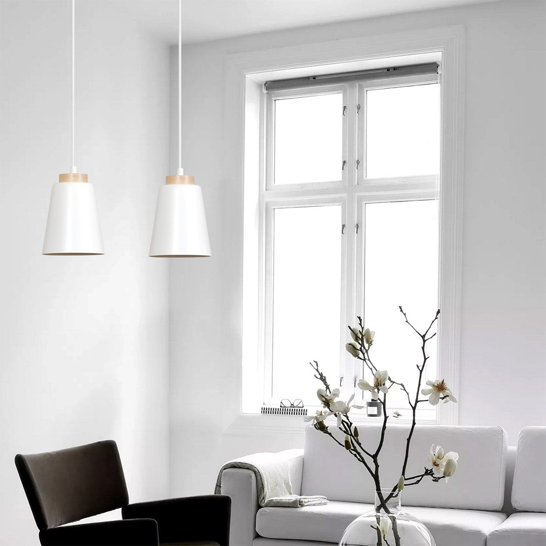 Mise en ambiance dans un salon blanc, suspensions devant une grande fenêtre