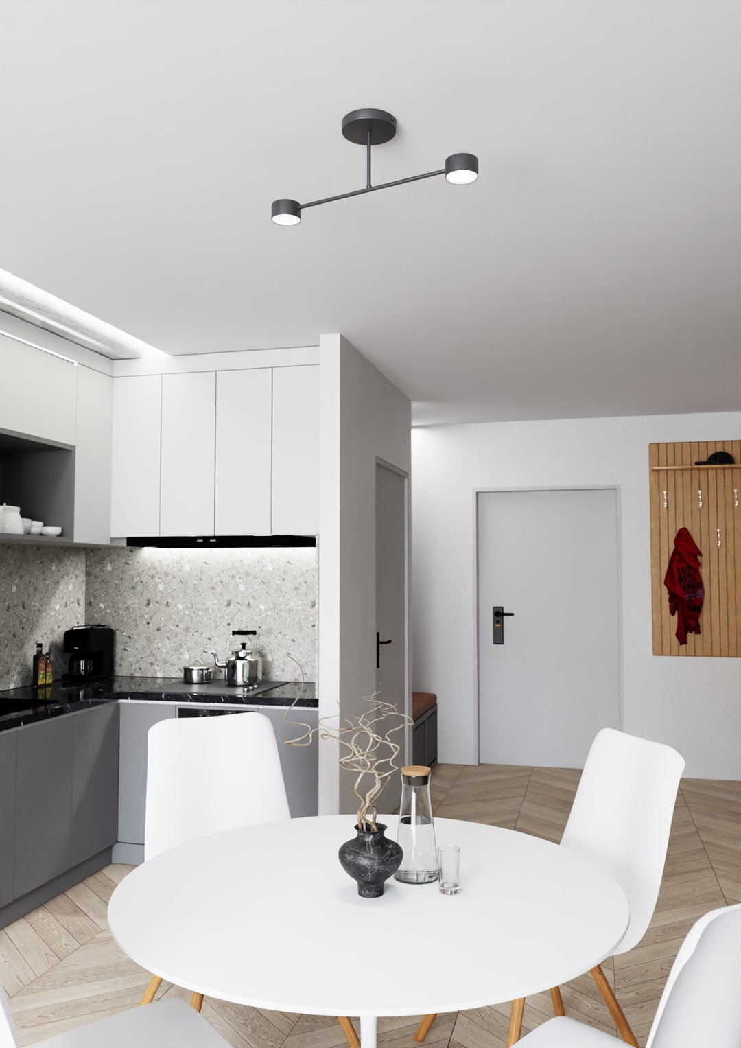 Mise en ambiance dans une cuisine ouverte, luminaire allumé au-dessus de la table ronde blanche.