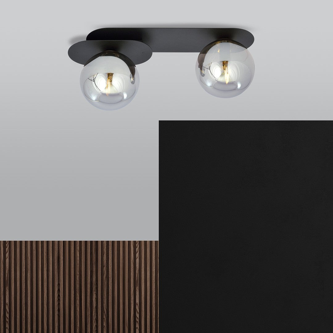 Luminaire fixé au plafond devant un mur noir et un panneau de bois strié