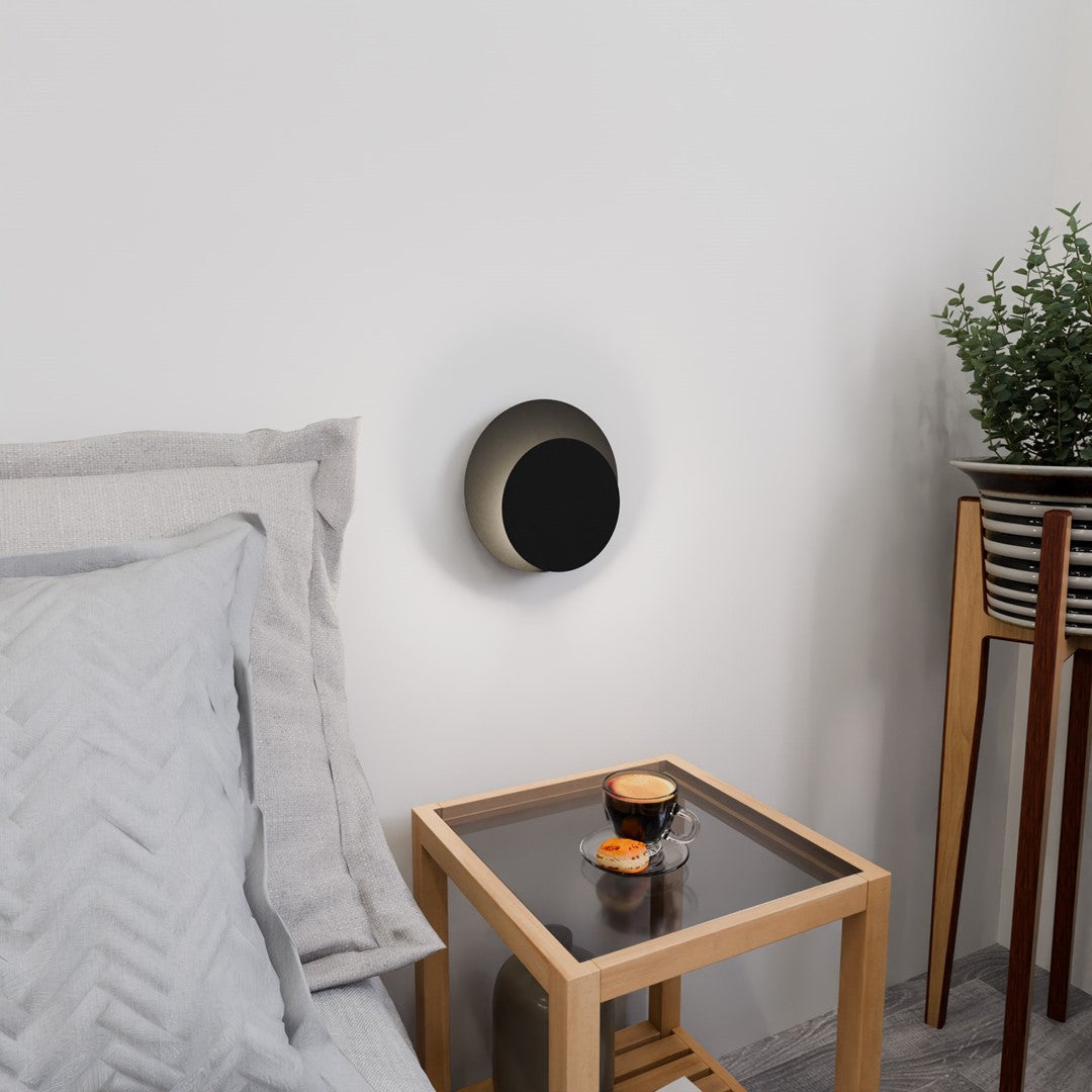 Luminaire mural rond en situation, table d'appoint avec tasse de café et plante