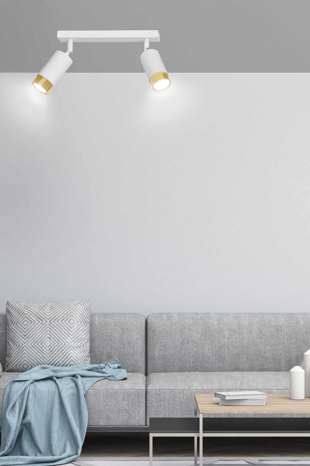 Mise en ambiance dans un salon gris, plafonnier allumé au-dessus du canapé.
