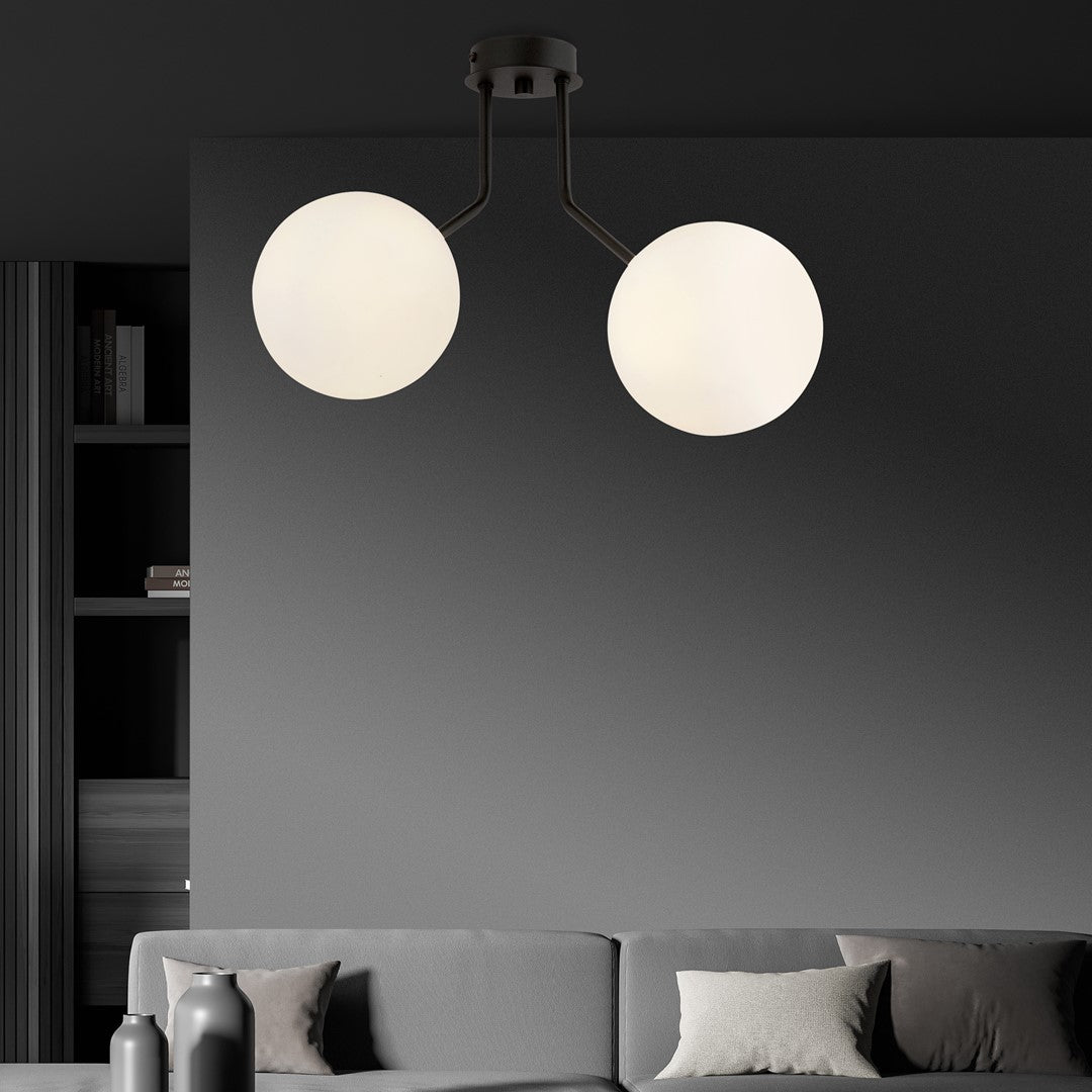 Mise en ambiance : suspension noire allumée dans un salon contemporain avec mur en marbre.