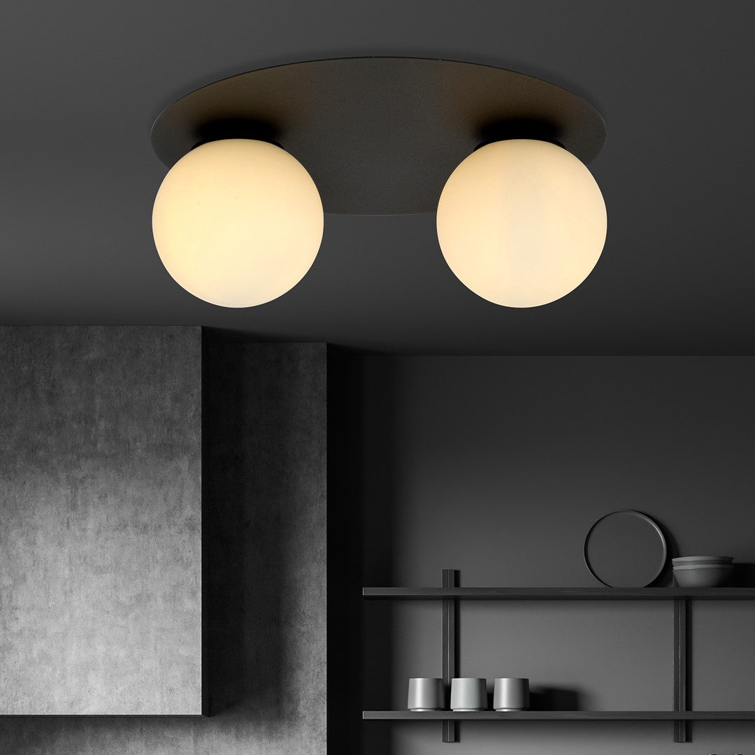 Plafonnier allumé au plafond dans un décor sombre, étagères et objets.