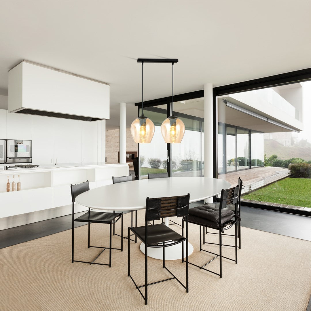 Mise en ambiance au-dessus d'une table ovale dans une cuisine ouverte lumineuse.