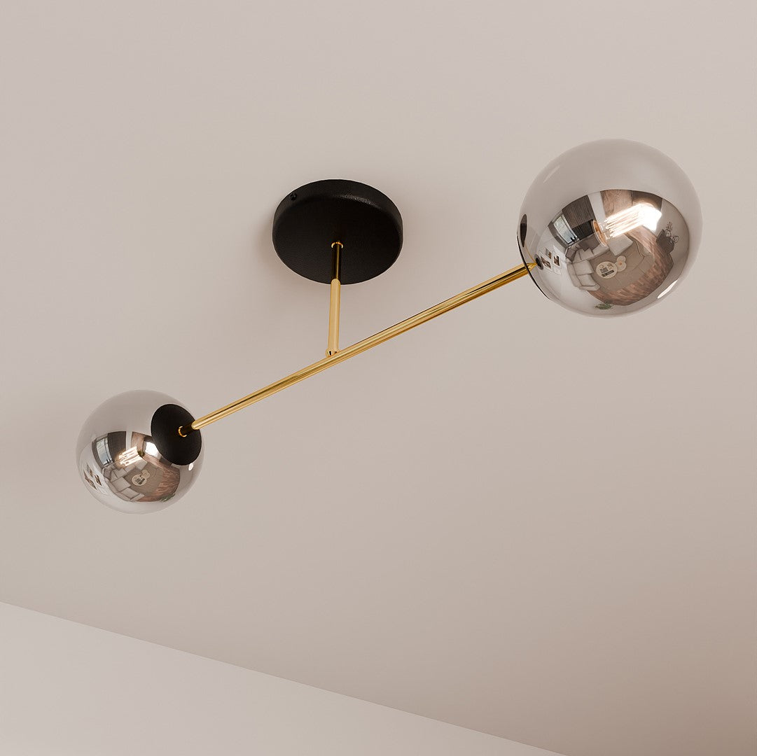 Détail des globes en verre fumé réfléchissant, bras doré et socle noir