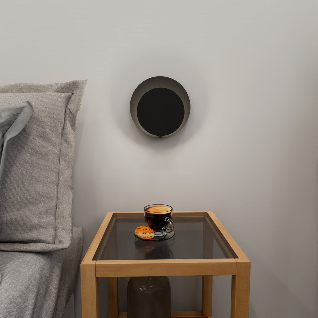 Vue frontale de l'applique noire éclairée au-dessus d'une table basse en bois