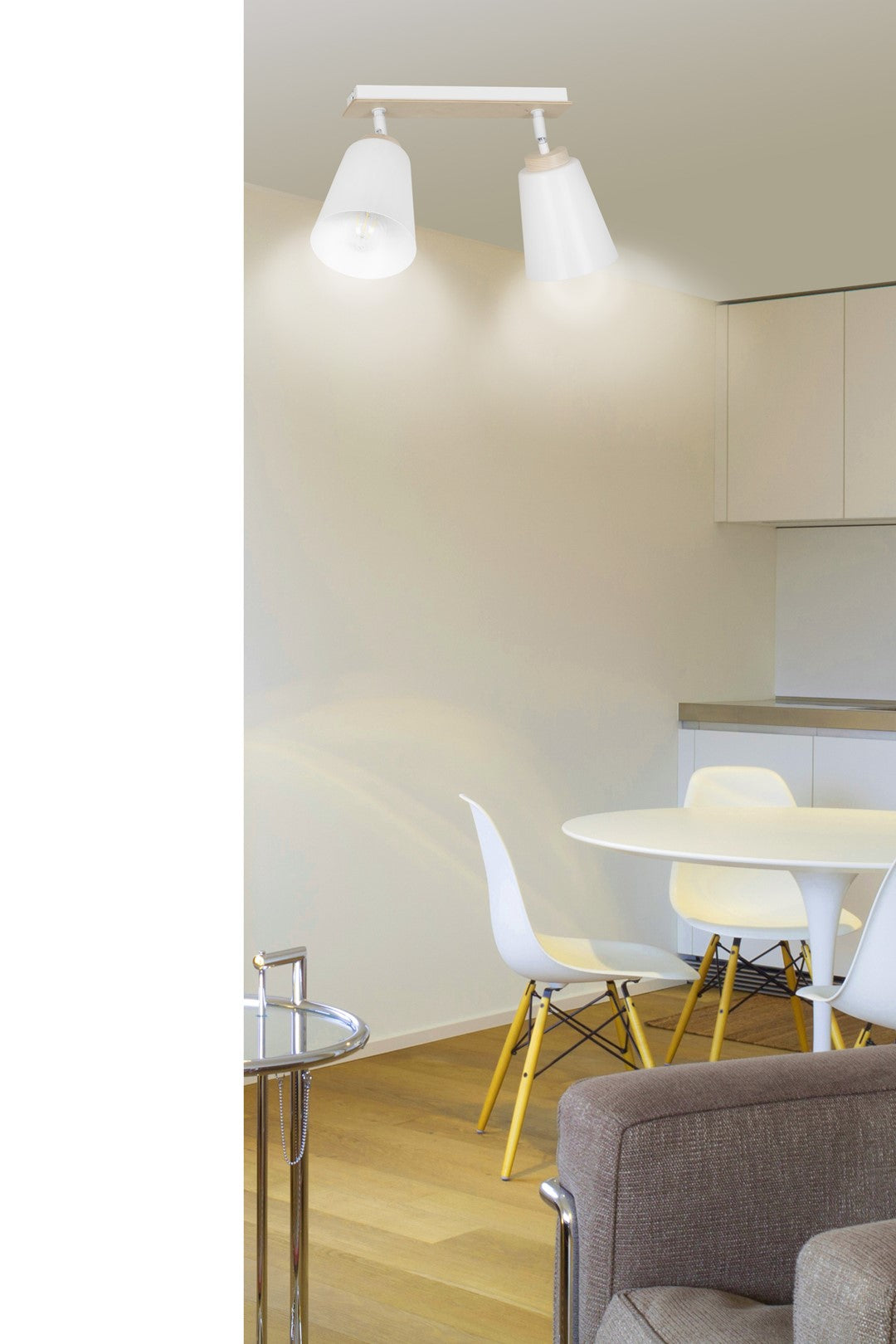 Mise en ambiance au-dessus d'une table de salle à manger avec chaises blanches.