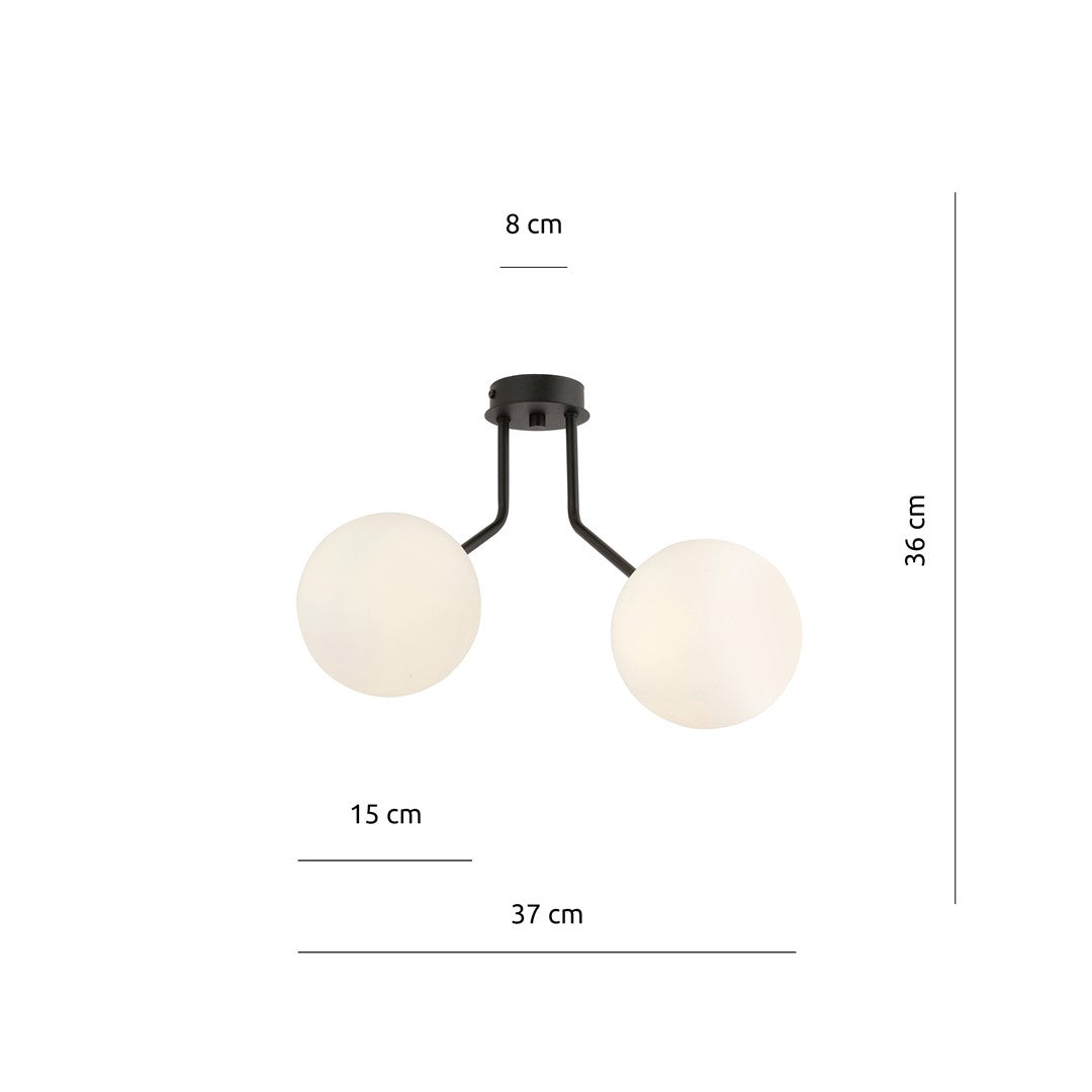 Luminaire allumé au-dessus d'un canapé dans un intérieur sombre et épuré.