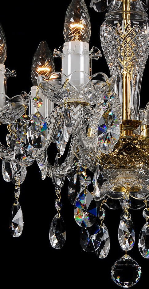 Gros plan sur les bras, coupelles ciselées et pendentifs aux reflets irisés.