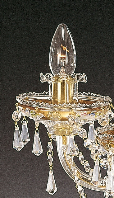 Détail rapproché d'une ampoule et de sa bobèche ornée de cristaux taillés et de gouttes pendantes.